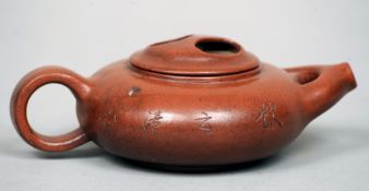 A Chinese Yixing teapot
Of squat cylindrical form with calligraphic decoration, the underside with