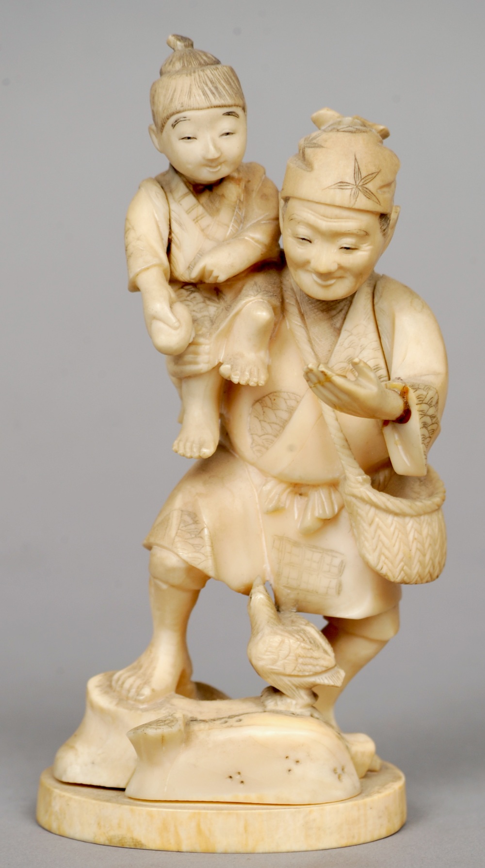 A 19th century Japanese ivory okimono
Formed as a father carrying his son on his shoulder, a small
