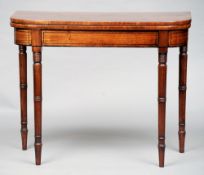 An early 19th century mahogany card table
The hinged crossbanded rounded rectangular top enclosing a