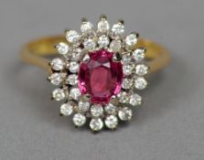 An 18 ct gold ruby and diamond cluster ring
The central ruby bordered by two rows of diamonds,