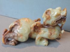 A Chinese carved green and russet jade mythical beast
17 cms long.   CONDITION REPORTS:  Generally