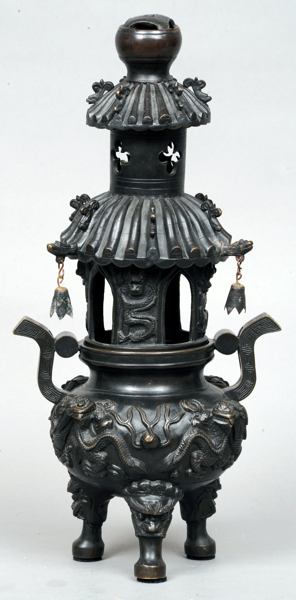 An Oriental patinated bronze koro
The pagoda form top above twin scrolling handles, the main body