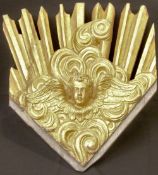 A 19th century carved giltwood sunburst panel
The stylised rays flanking a winged cherubs mask.