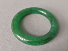 A Chinese carved green jade bangle
8 cms diameter.   CONDITION REPORTS:  Generally in good