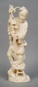 A large 19th century Japanese ivory group
Modelled as a farmer holding a grapevine, a young boy
