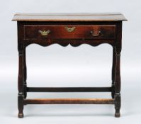 An 18th century oak side table
The moulded rectangular top above a serpentine frieze with a single