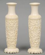 A pair of ivory vases
Each of cylinder form and carved with floral decoration, standing on a foliate