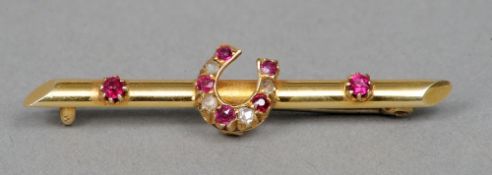 An Edwardian 15 ct gold ruby and diamond set bar brooch
Centrally set with a horseshoe.  4 cms wide.