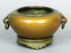 A Chinese bronze censor on stand
Of typical circular bulbous form with twin ring and loop handles,