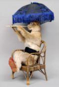 A stuffed and mounted musical monkey
Seated on a cane armchair enclosing a musical movement, the