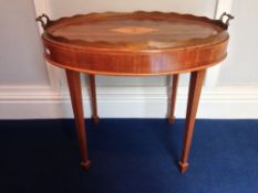 A rosewood veneered oval twin handled tray on stand
With central shell inlay and wavy gallery, the