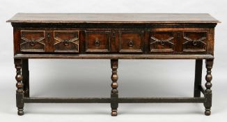 An 18th century and later oak low dresser
The moulded rectangular top above three geometrically