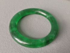 A Chinese carved green jade bangle
8.5 cms diameter.   CONDITION REPORTS:  Generally in good