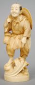 A 19th century Japanese carved ivory okimono
Formed as a gentleman wading with a straw hat over