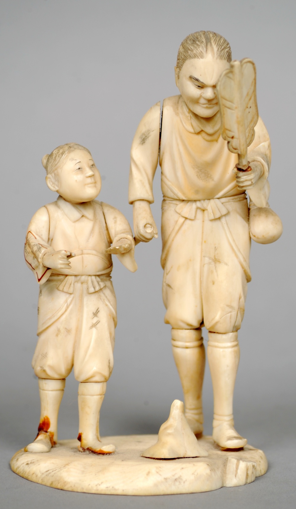 A 19th century Japanese ivory okimono
Formed as two figures, one holding a fan.  13.5 cms high.