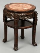 A Chinese carved hardwood side table
The bead moulded circular top with a marble insert above a