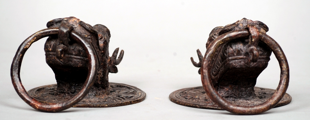 A pair of Tibetan patinated bronze loop handles
Each pierced back plate issuing a dragons head.