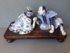 A late 19th century Japanese porcelain figural group
Formed as two figures arm wrestling,