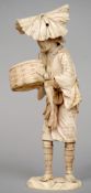 A 19th century Japanese ivory okimono
Formed as a farmer holding a basket and a vegetable and