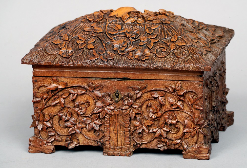 A 19th century Black Forest carved box
Formed as a cottage with scrolling floral decoration.  21 cms