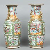 A pair of 19th century Cantonese famille rose vases
Each flared rim above gilt decorated twin dog-