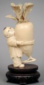 A 19th century Oriental carved ivory figure
Formed as a young boy holding a giant turnip, standing