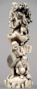 A carved ivory okimono
Depicting various figures and a performing monkey, the underside with