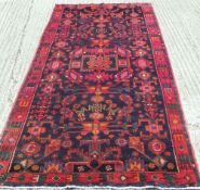 A Hamadan wool rug
The midnight blue field extensively filled with flowering vines, rosettes and