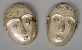 Two white metal African type masks
Each stylistically modelled with symbolic motifs to the