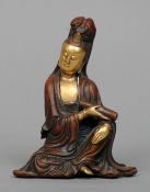 A Chinese gilt and patinated bronze figure of Guanyin
Seated holding a scroll.  11 cms high.