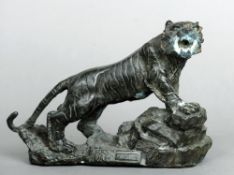 A Chinese patinated bronze tiger
Naturalistically modelled astride rockwork.  20 cms wide.