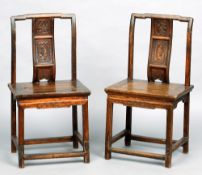 A pair of Chinese temple chairs
The curved back splat decorated with a figural panel above the solid