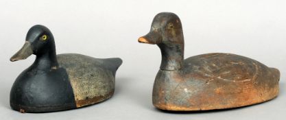 An early 20th century carved wooden decoy duck and another carved wooden hollow decoy duck 
The