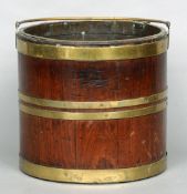 A 19th century brass bound mahogany bucket
The tubular swing handle above the banded main body.