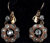 A pair of unmarked gold diamond set drop earrings
Each of target form.  1.5 cms diameter.