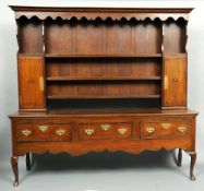An 18th century oak dresser
The moulded cornice over the serpentine frieze above plate racks and