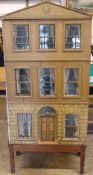 A large early 19th century dolls house
The three storey building with an arched pediment painted