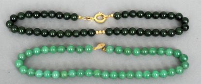 A spinach green jade bead necklace
Set with an 18 ct gold clasp; together with another bead