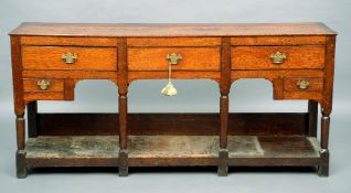 A George III oak dresser base
The rectangular top above an arrangement of five drawers with brass