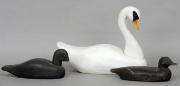 Two carved wooden duck decoys and a carved wooden swan decoy
The latter 45 cms long.  (3)