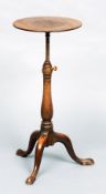 A 19th century mahogany extending tripod wine table
The adjustable circular top above the column