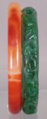 A spinach jade bangle
Carved with scrolling floral motifs; together with an agate bangle of