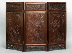 A late 19th/early 20th century Chinese carved  hardwood triptych screen
The three panels carved