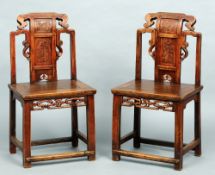 A pair of Chinese temple chairs
The carved curved top rail above a carved back splat over the