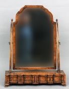 An 18th century style burr walnut framed dressing table mirror
The shaped mirror plate flanked by