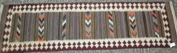 A Kilim wool runner
The central field with geometric bands within a geometric border.  290 x 77 cms.