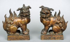 A pair of Chinese patinated bronze dogs-of-Fo
Each typically modelled standing on plinth base.  Each