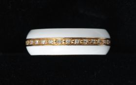 An 18 ct gold diamond set band
The central row of diamonds bordered by white enamelled borders.