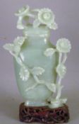 A carved jade vase and cover
Decorated with flowering foliate sprays.  16.5 cms high.   CONDITION