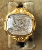A 19th century unmarked gold mourning ring
The scrolling shank centred with a hair plait, the